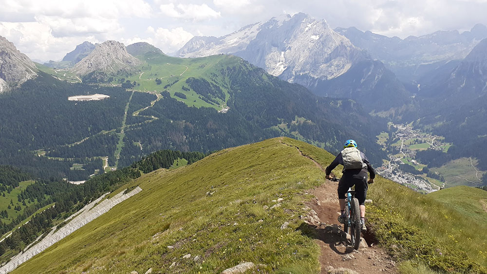 Mountainbiker am Trail Blick Sellajoch Marmolada und Canazei