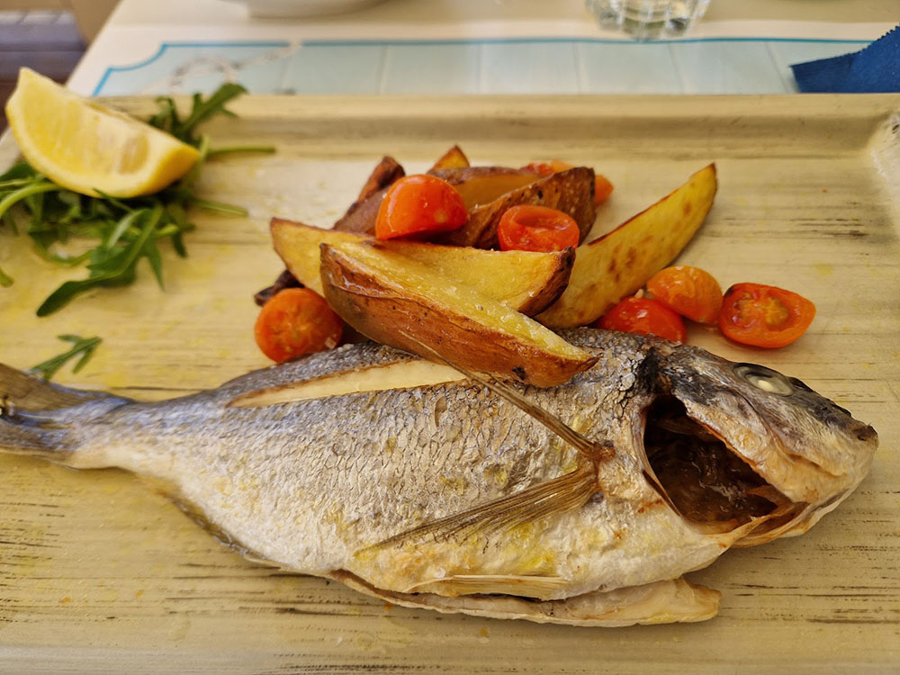 Meeresfisch mit Kartoffeln und Tomaten