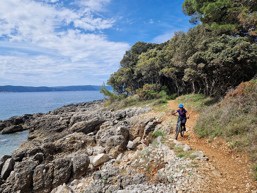 Mountainbiker am Trail mit Meerblick